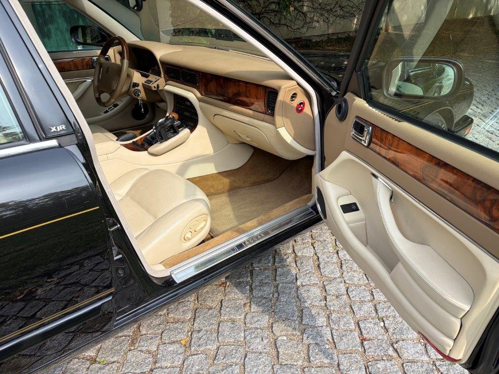 Jaguar XJR Innenraum mit hellem Leder und Wurzelholz durch geöffnete Tür